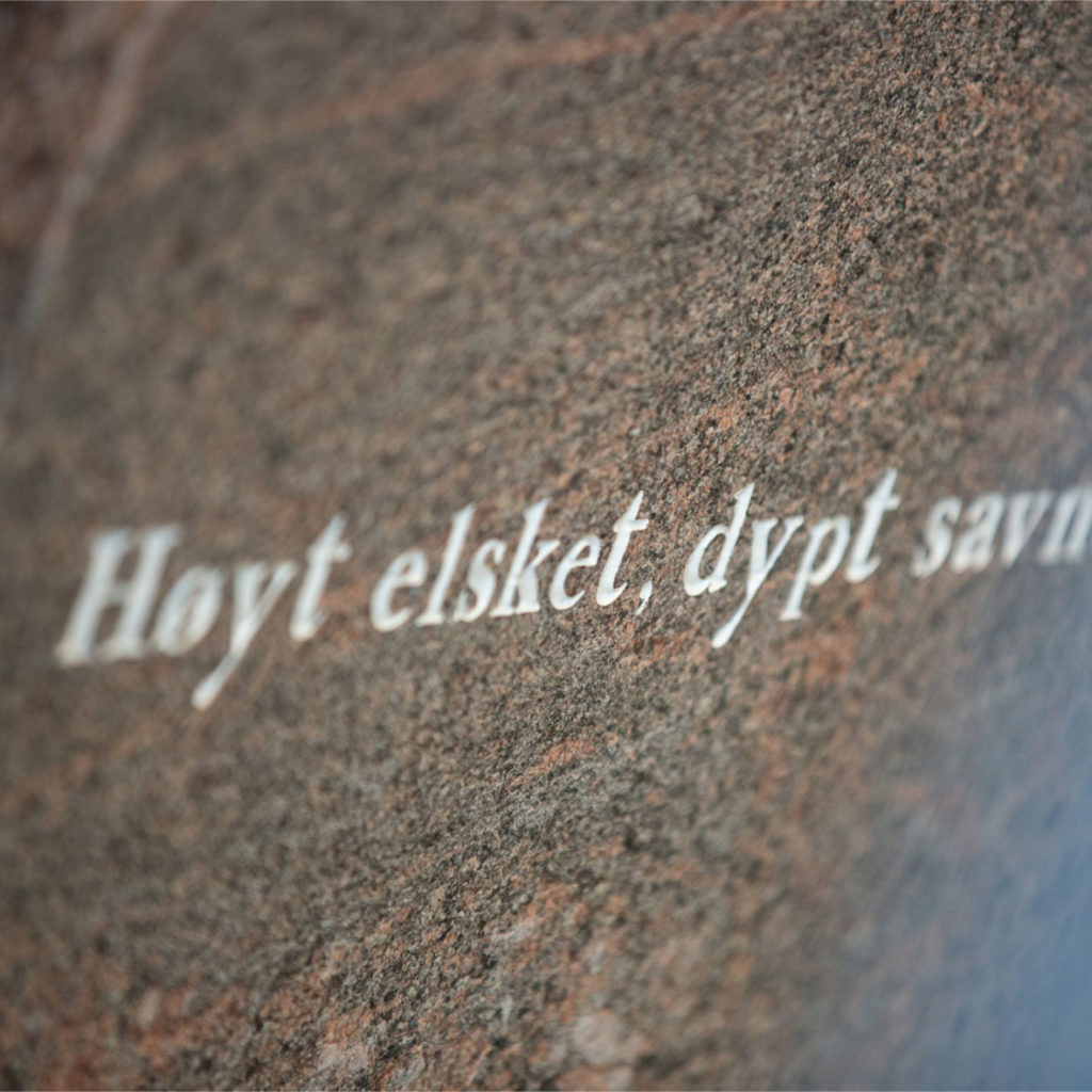 Nærbilde av en gravsten med teksten " Høyt elsket, dypt savnet"